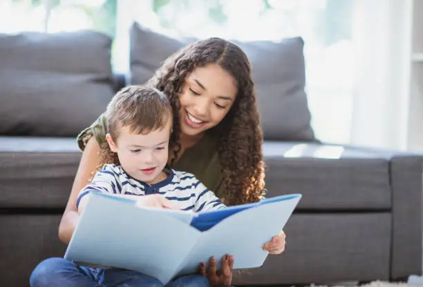 A friendly local babysitter reading with a child
